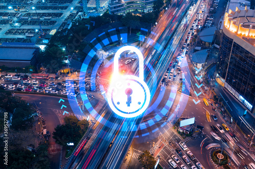 Padlock icon hologram on aerial view of road  busy urban traffic highway at night. Junction network of transportation infrastructure. The concept of success in cyber security intelligence.