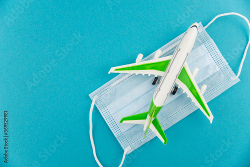 Safe travels concept. Plane with surgical medical mask. Safety flight and travel during quarantine and lockdown.