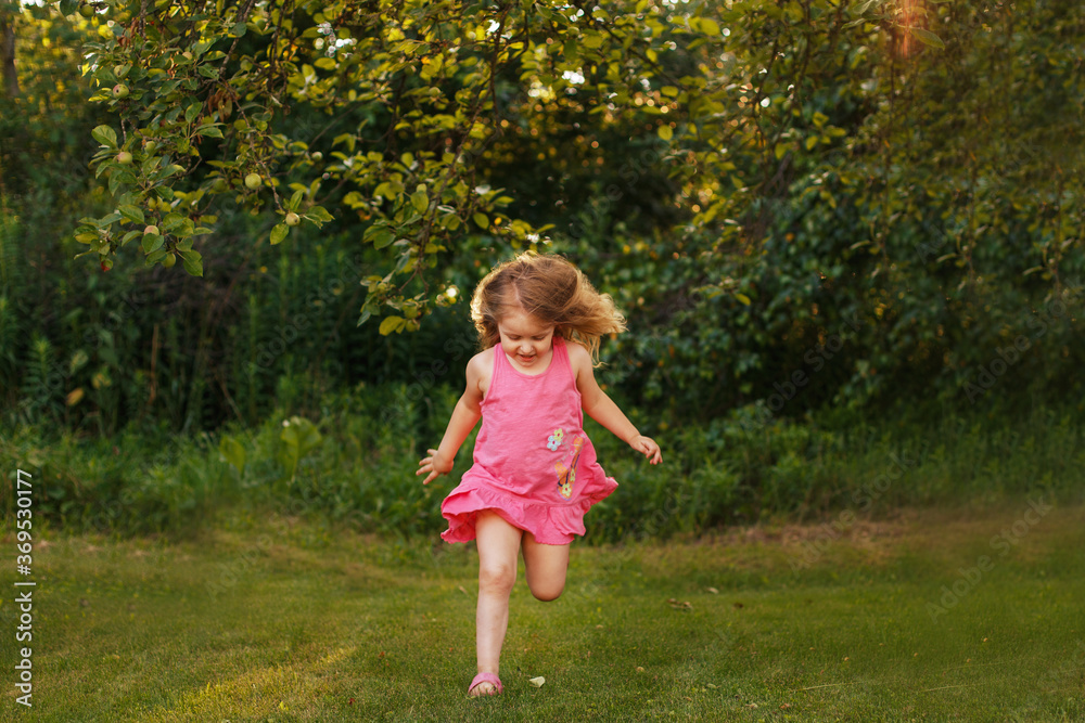 happy baby smiling. little girl running at a sunset outdoor happy baby smiling. little girl running at a sunset outdoor