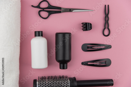 Fototapeta Naklejka Na Ścianę i Meble -  Professional hair dresser tools with copy space. Hair stylist equipment set on pink background. Scissors, brush, hairbrush, balm flat lay top view.