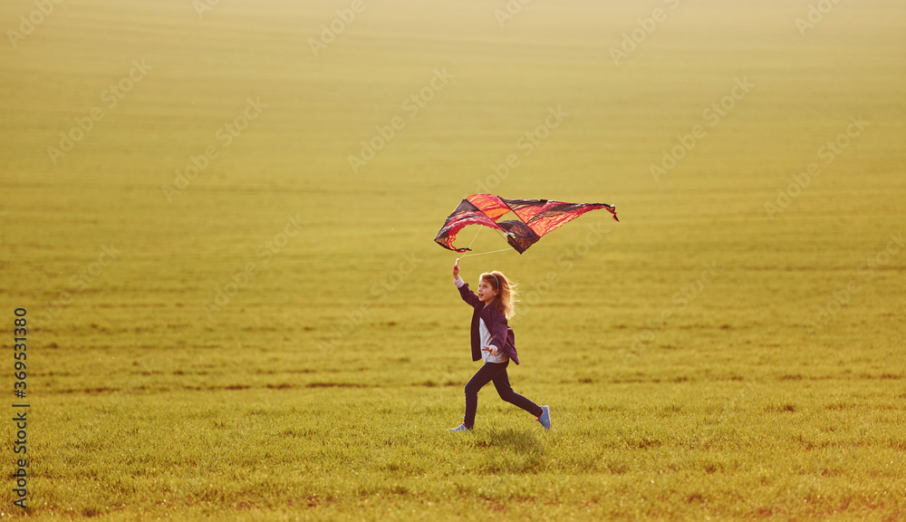Happy little girl running with kite in hands on the beautiful field Happy little girl running with kite in hands on the beautiful field