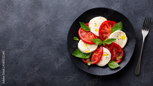 Fotografía Caprese salad with tomatoes, mozzarella cheese, basil