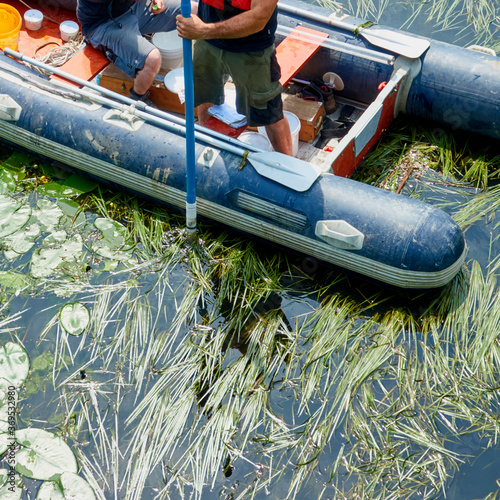 Photography Taking a sediment sample from an inflatable boat with a sediment sampler