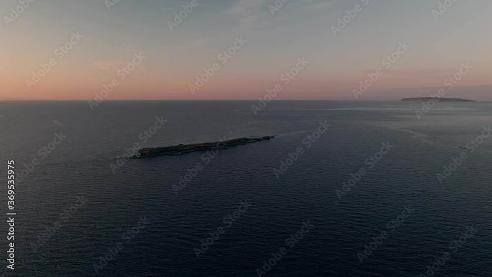 Small Rocky Island By The Gulf Of Saint Lawrence During A Beautiful Sunrise In Quebec, Canada. - aerial drone Small Rocky Island By The Gulf Of Saint Lawrence During A Beautiful Sunrise In Quebec, Canada. - aerial drone