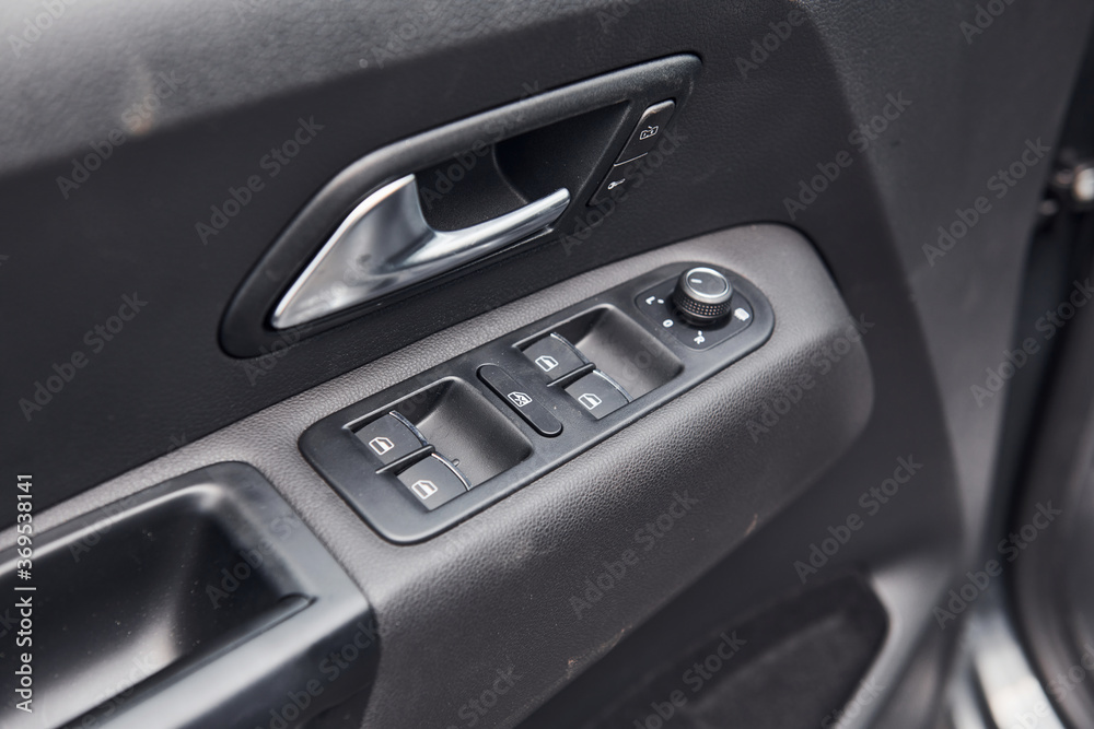 Close up view of modern automobile's door. Buttons and knobs