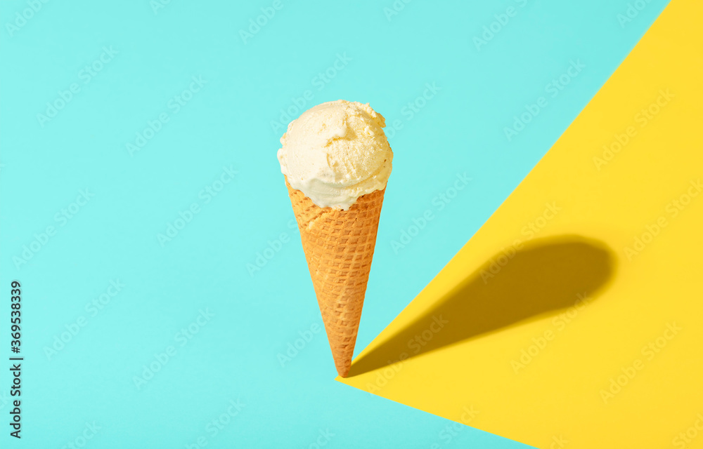 Vanilla ice cream cone in bright light. Waffle cone ice cream on summer colors Vanilla ice cream cone in bright light. Waffle cone ice cream on summer colors
