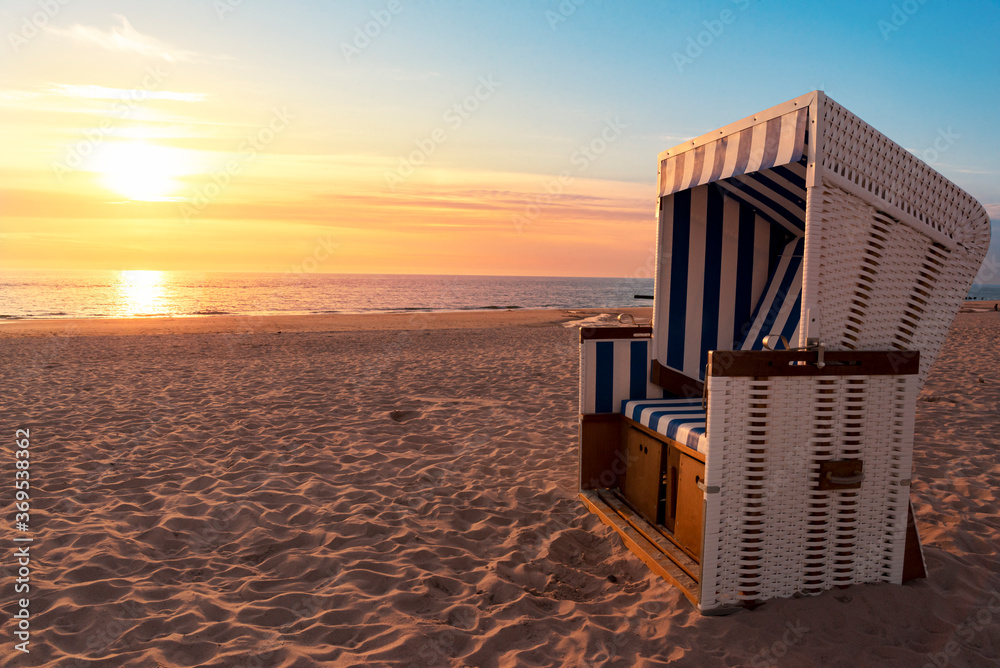 Summer beach at sunset. Empty beach chair on North Sea shore, on Sylt island Summer beach at sunset. Empty beach chair on North Sea shore, on Sylt island