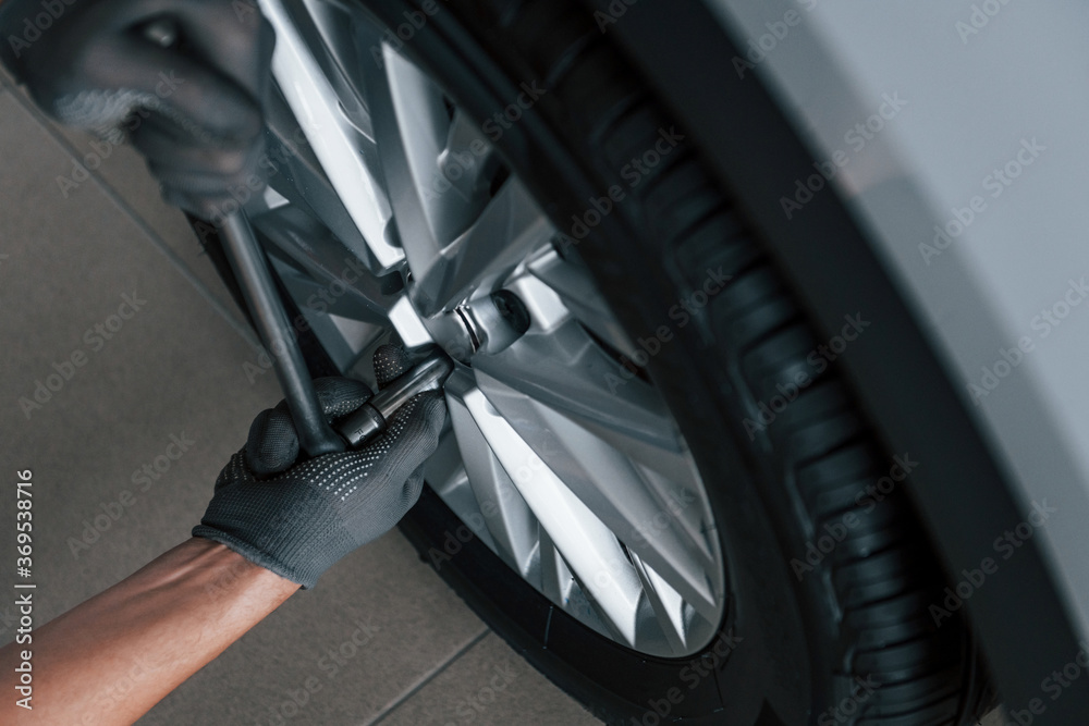 Close up view of man that changing tire of automobile. Conception of car service