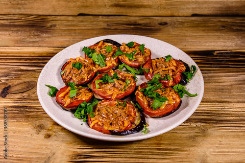 Baked eggplants with tomatoes and cheese in a ceramic plate