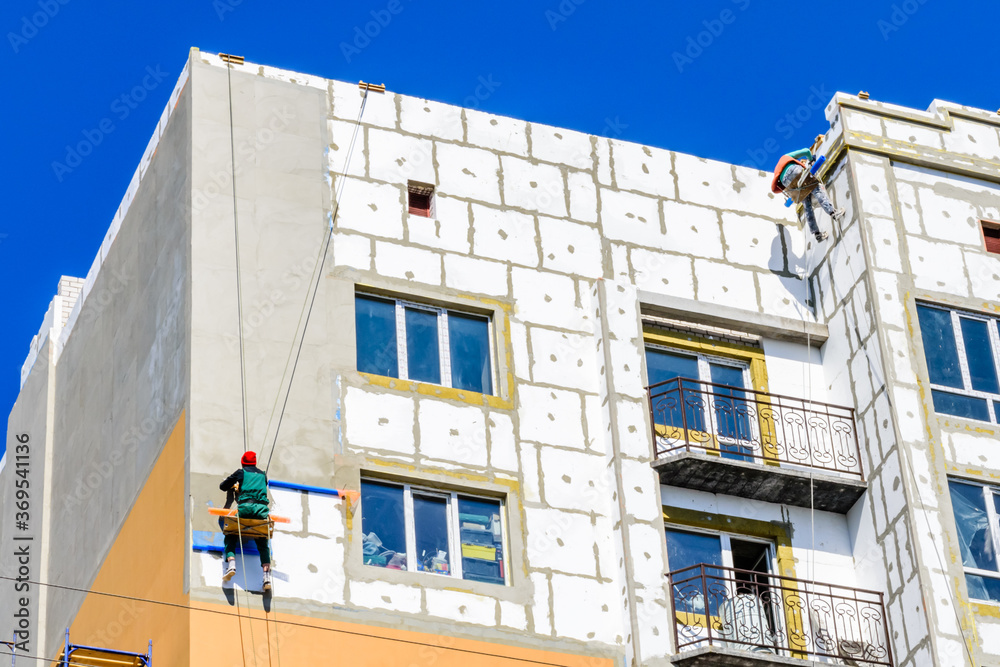 Insulation of the multistory residential building with styrofoam. Rope ...