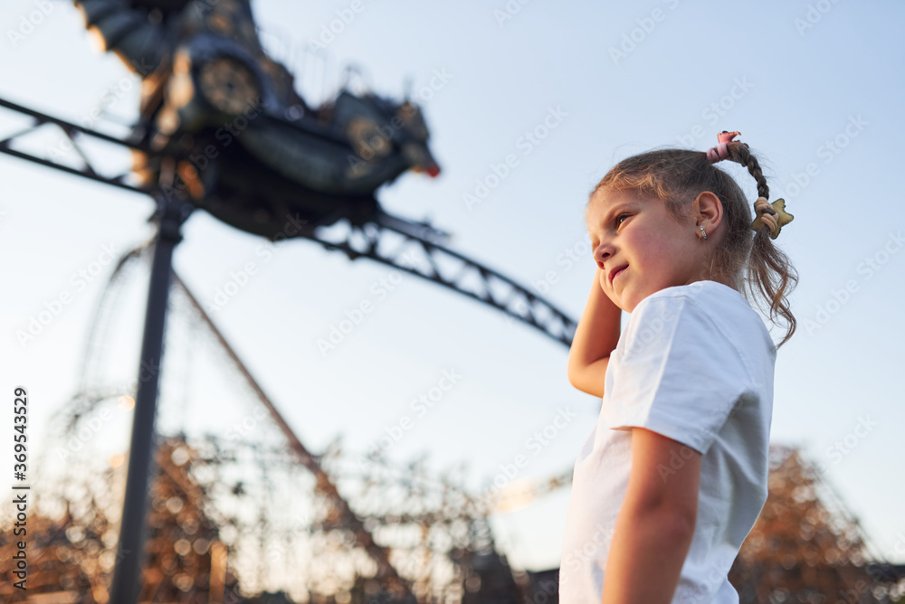 Little girl have fun at children's amusement park at daytime