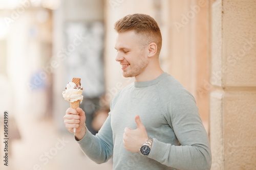 Male tourist holding Italian ice cream in cone and smiling