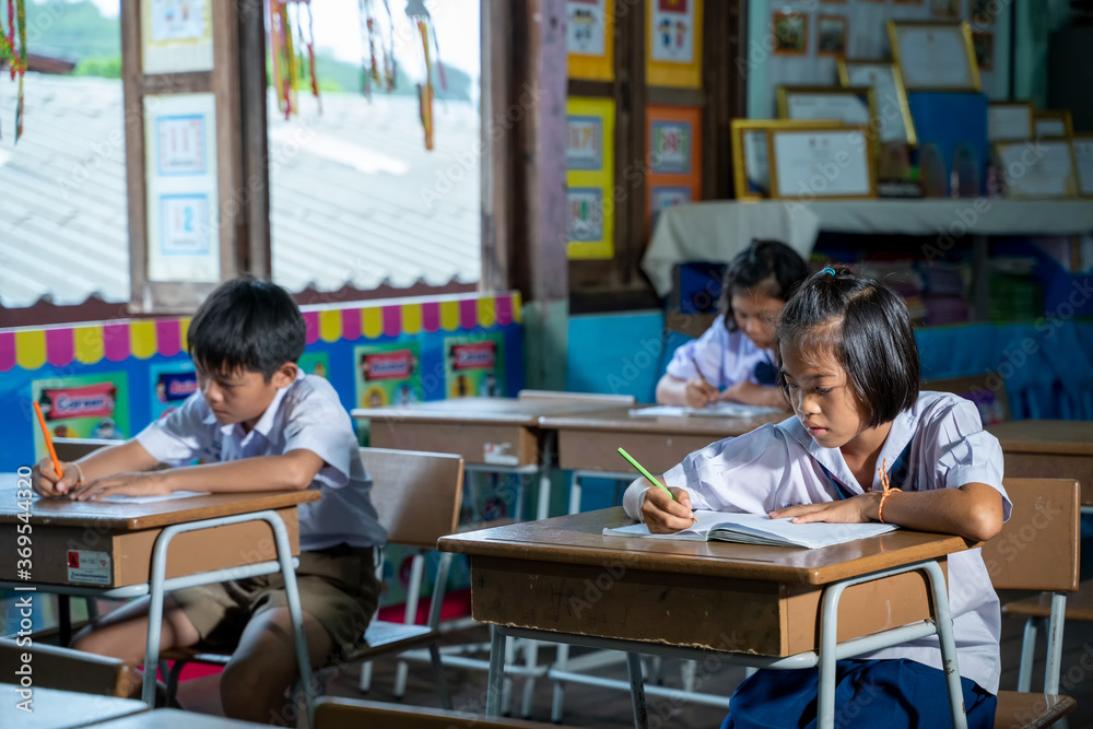 Asian elementary students in uniform studying together at classroom,Education,Student,People concept. Asian elementary students in uniform studying together at classroom,Education,Student,People concept.
