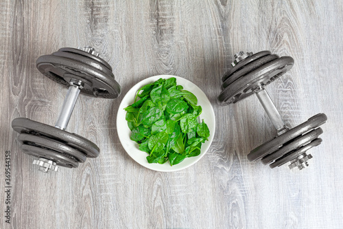 Set of weights and baby spinach on a plate