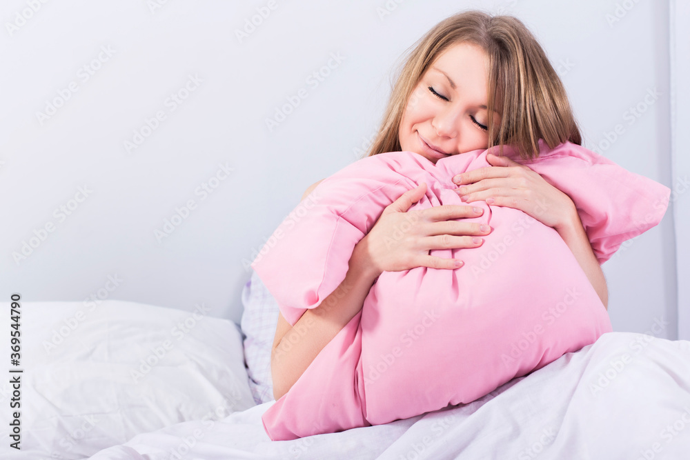 Beautiful blonde woman sleeping in her bed in pajamas, smiling Beautiful blonde woman sleeping in her bed in pajamas, smiling
