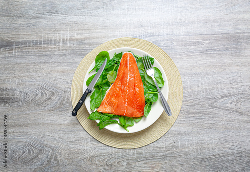 Salmon on a plate with baby spinach leaves