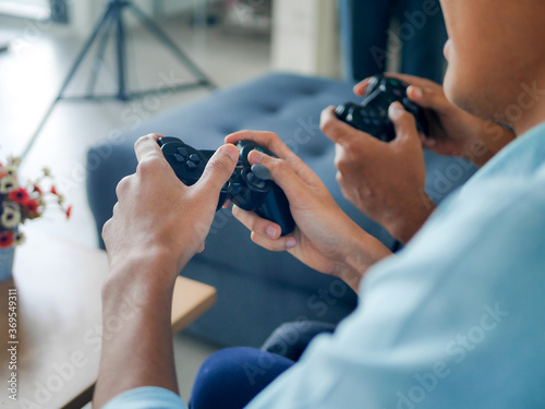 hands of old Asian father was spending joyful time with mature adult son at home on couch. enjoying technology lifestyle concept. social distancing new normal concept. 