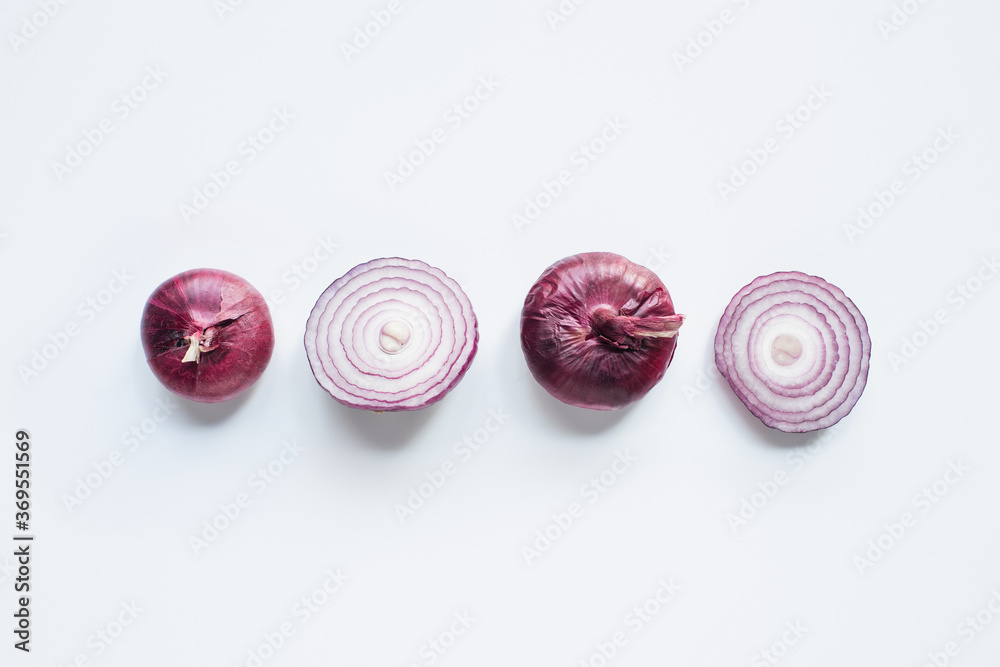 Obraz premium top view of cut and whole red onion on white background