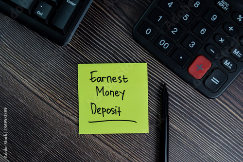 Earnest Money Deposit write on sticky notes isolated on office desk.