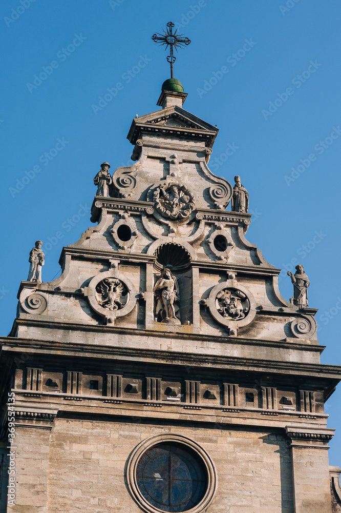 Roof of the Bernardine Church of St. Andrew with sculptures of Jesus, Mary and monks. Dome with a cross of Renaissance architecture in Lviv, Ukraine.
