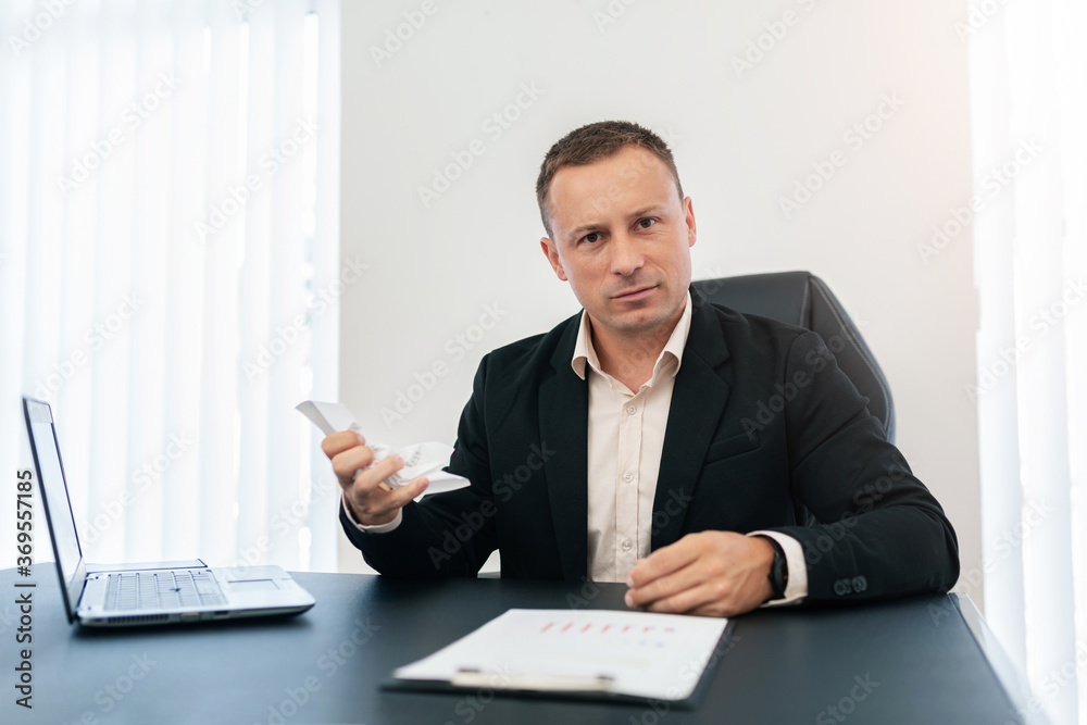 The man angrily crumples the paper. The man angrily crumples the paper.