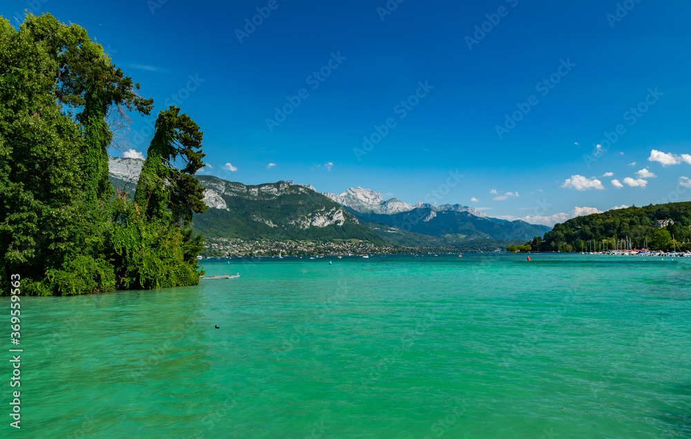 View of Annecy lake,boats with tourists and Alps mountains on sunny day with blue sky in Annecy city.Annecy is the largest city of Haute-Savoie department in France.