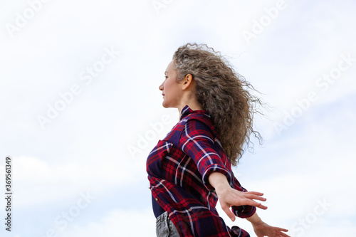 The woman spread her arms to the sides against the sky