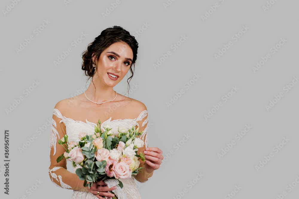 Bride in white wedding dress with bouquet looks in camera in studio on white blank background right side. Advert for social networks for wedding agency and bridal salon Bride in white wedding dress with bouquet looks in camera in studio on white blank background right side. Advert for social networks for wedding agency and bridal salon
