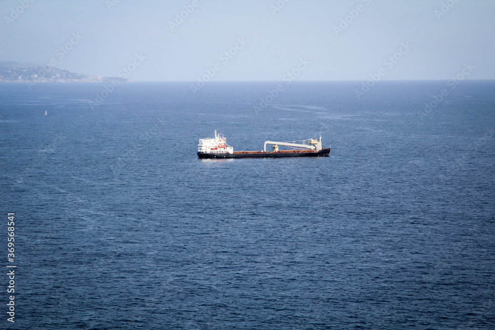 Ein Schiff, oder ein Spezialschiff liegt auf Reede vor dem Hafen.