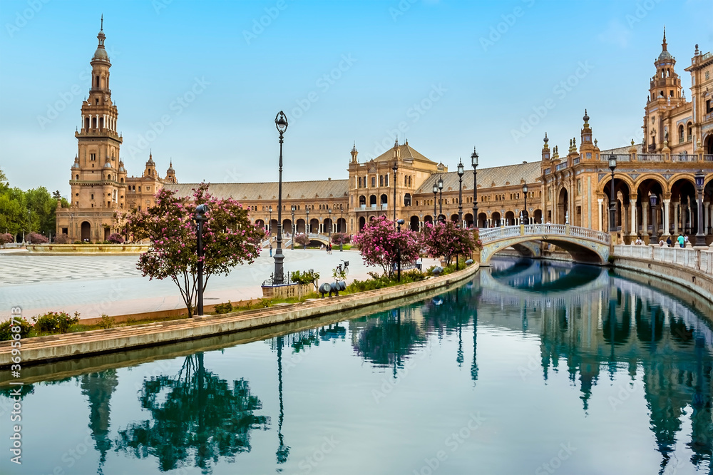 The canal in the Plaza de Espana in Seville, Spain sweeps around towards the north tower in the early morning in summertime