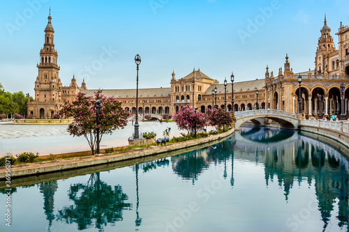 The canal in the Plaza de Espana in Seville, Spain sweeps around towards the north tower in the early morning in summertime © Nicola