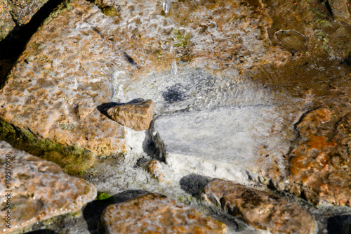 Obraz na plátně Mineral deposition on stones by dripping water from a healing spring