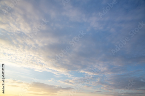 white and pink Cirrus clouds on a blue sky on a summer evening, background
