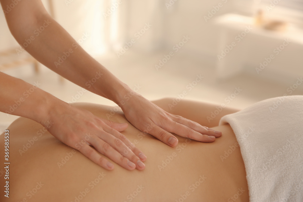 Young woman receiving back massage in spa salon, closeup