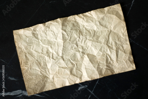 rumpled sheet of old paper on a black background
