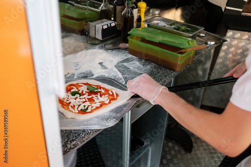 The process of making pizza. Cook prepares pizza Margherita.