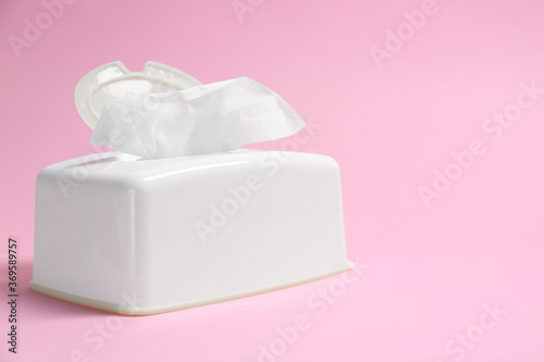 Holder with paper tissues on pink background
