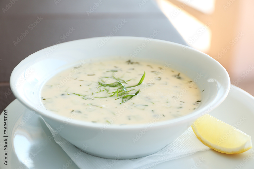 Delicious soup served with lemon slice, closeup