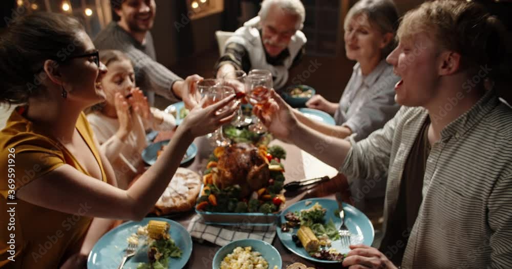 Large caucasian family celebrating thanksgiving day, making a toast and clinking their glasses, positively smiling - celebration concept 4k footage