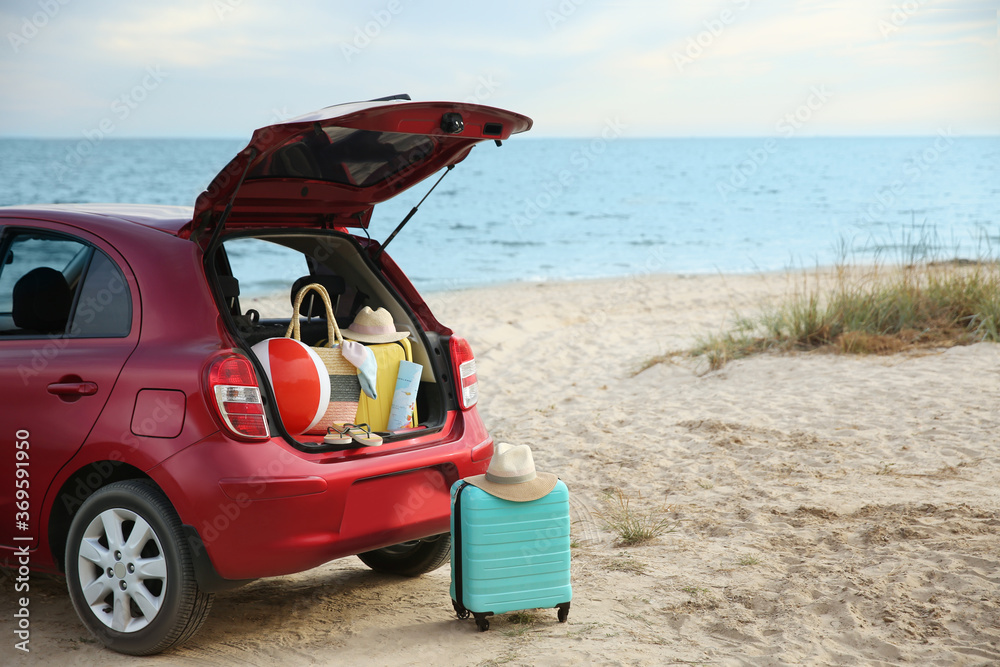 Red car luggage on beach, space for text. Summer vacation trip Red car luggage on beach, space for text. Summer vacation trip