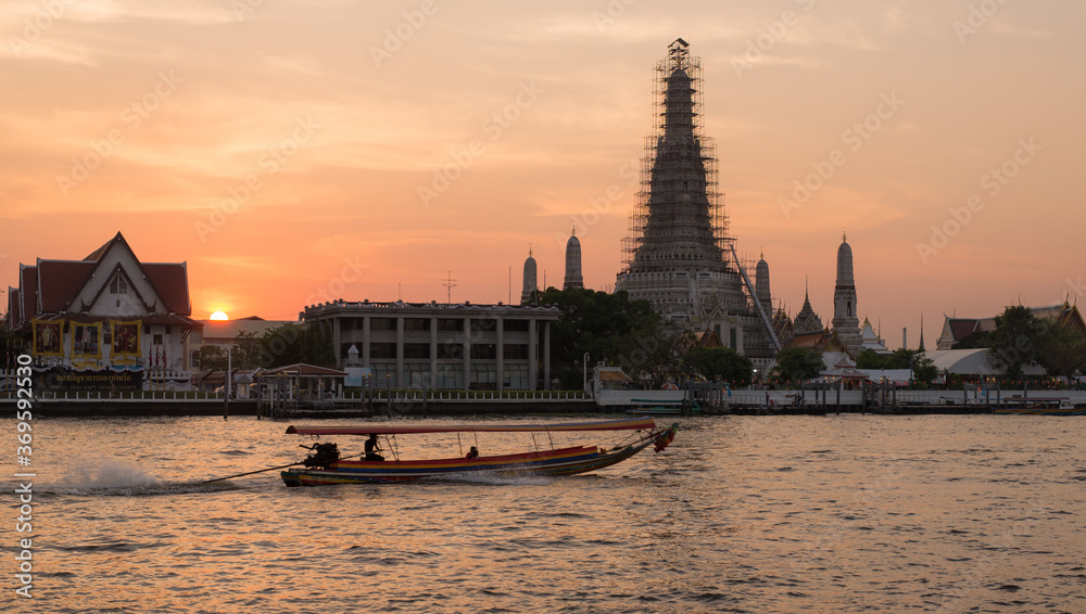 boat on river in front of temple in bangkok