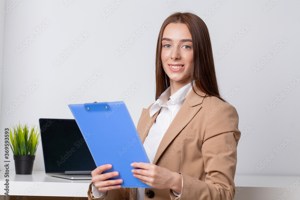 Happy beautiful business woman with clipboard in the office. Happy beautiful business woman with clipboard in the office.