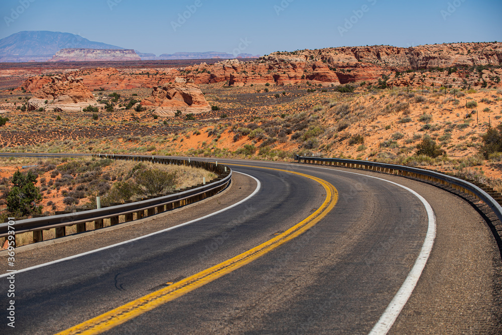 Desert highway at sunset, travel concept, USA. Asphalt road and canyon background.