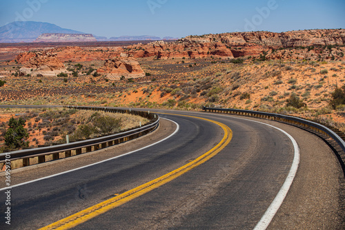Desert highway at sunset, travel concept, USA. Asphalt road and canyon background.