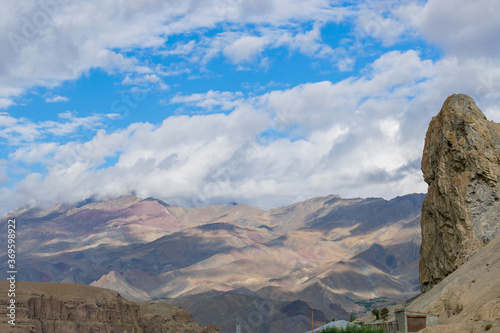 Shadows of clouds on Himalayan mountains at Mulbek, Ladakh. Blue sky with white clouds in the background.