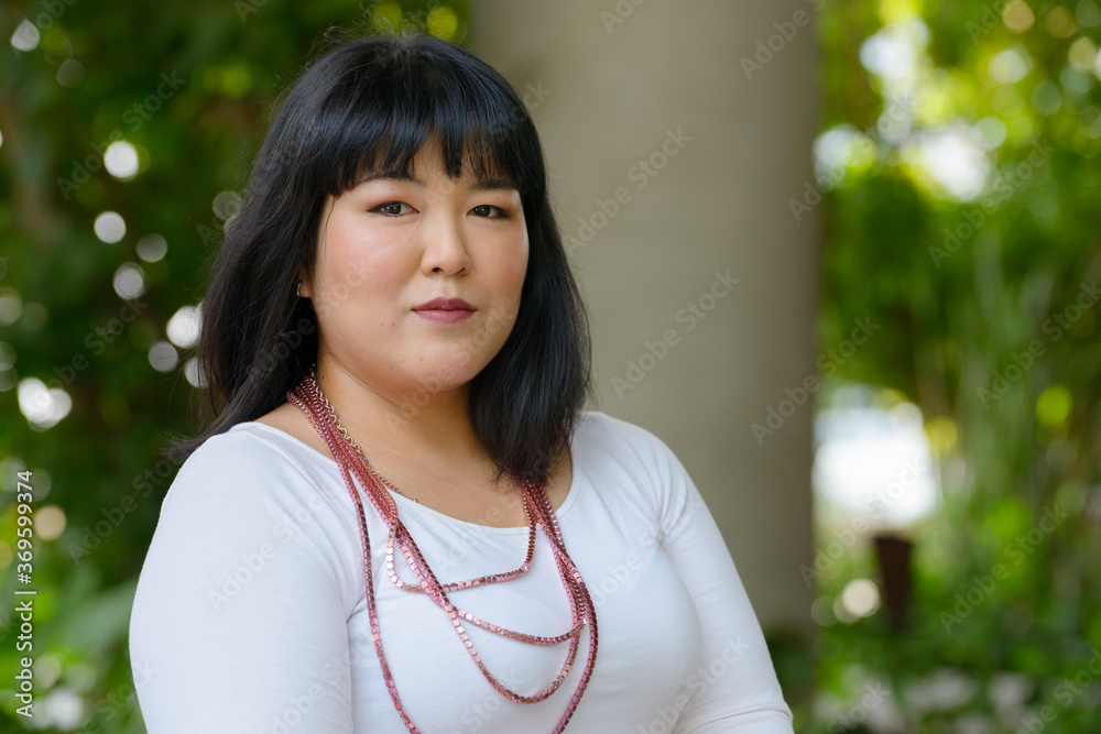 Young beautiful overweight Asian woman at the park Young beautiful overweight Asian woman at the park