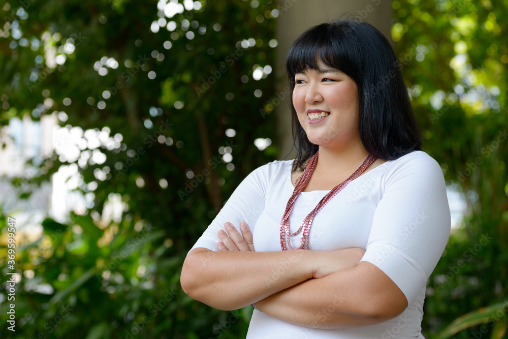 Happy young beautiful overweight Asian woman at the park Happy young beautiful overweight Asian woman at the park