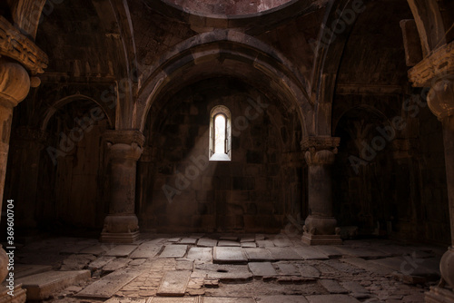 Obraz na płótnie Interior of old Sanahin Armenian Monastery of the Armenian Apostolic Church with ray of light entering through narrow window and headstones on uneven ground w salonie