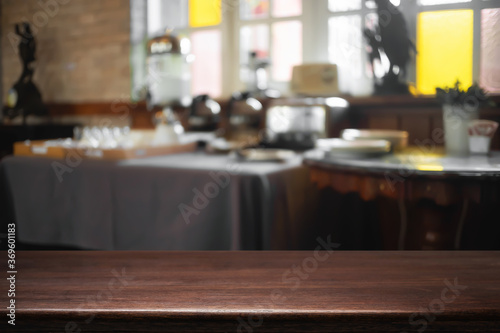 Empty wooden desk space and blurry background of cafe or Restaurant for product display montage.