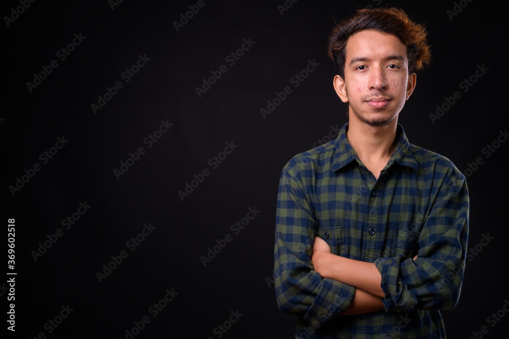 Naklejka premium Portrait of young Asian hipster man with curly hair